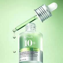 Anua 10+ serum bottle with dropper on a green background