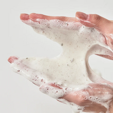 Hand with soap suds on a light background